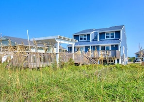 A two-story house with a covered porch and a fenced yard.
