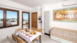 A dining area with a table set for two, a bench, and a painting on the wall. - 3365 A Casa di Anna - Ilaria by Barbarhouse (Vieste)