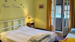 A bedroom with a bed, a bedside table, a lamp, a window with curtains, and a wall decoration. - Large apartment with pool and garden, ideal for families, 10 km from the sea. (Sarola)