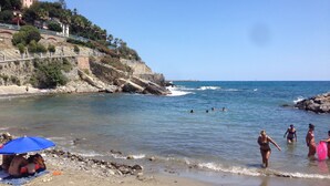 A beach with rocky terrain, a clear sky, and a few people in the water. - Large apartment with pool and garden, ideal for families, 10 km from the sea. (Sarola)