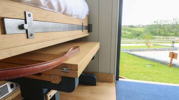 A bed with a wooden headboard, a pillow, and a brown leather strap.