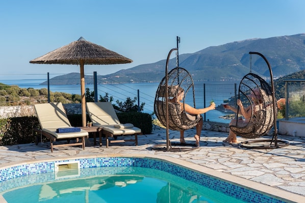 Relax by the pool with a serene mountain view.