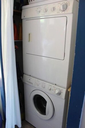 A front-loading washing machine in a laundry room.