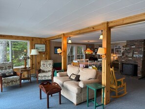 A cozy living room with a sofa, chairs, a fireplace, and a dining area. - Lake and Mountain views! (Sanbornton)