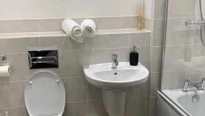 A bathroom with a toilet, sink, and shower. - Immaculate 2-bed Apartment in Grays (Grays)