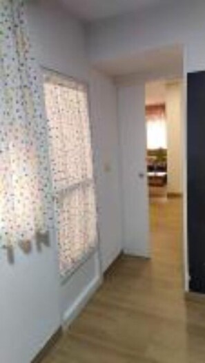 Leading to a cozy room with a window and a door.
