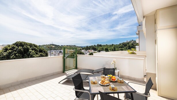A rooftop terrace with a table set for breakfast, chairs, and a view of the city. - 3362 Raggio di Sole by Barbarhouse (Vieste)