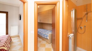 A compact room with a bed, a shower, and a radiator. - 3362 Raggio di Sole by Barbarhouse (Vieste)