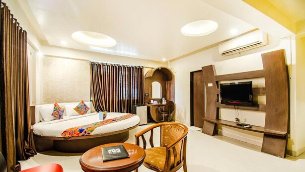 Une chambre d’hôtel avec un lit, une télévision, un bureau et une chaise.