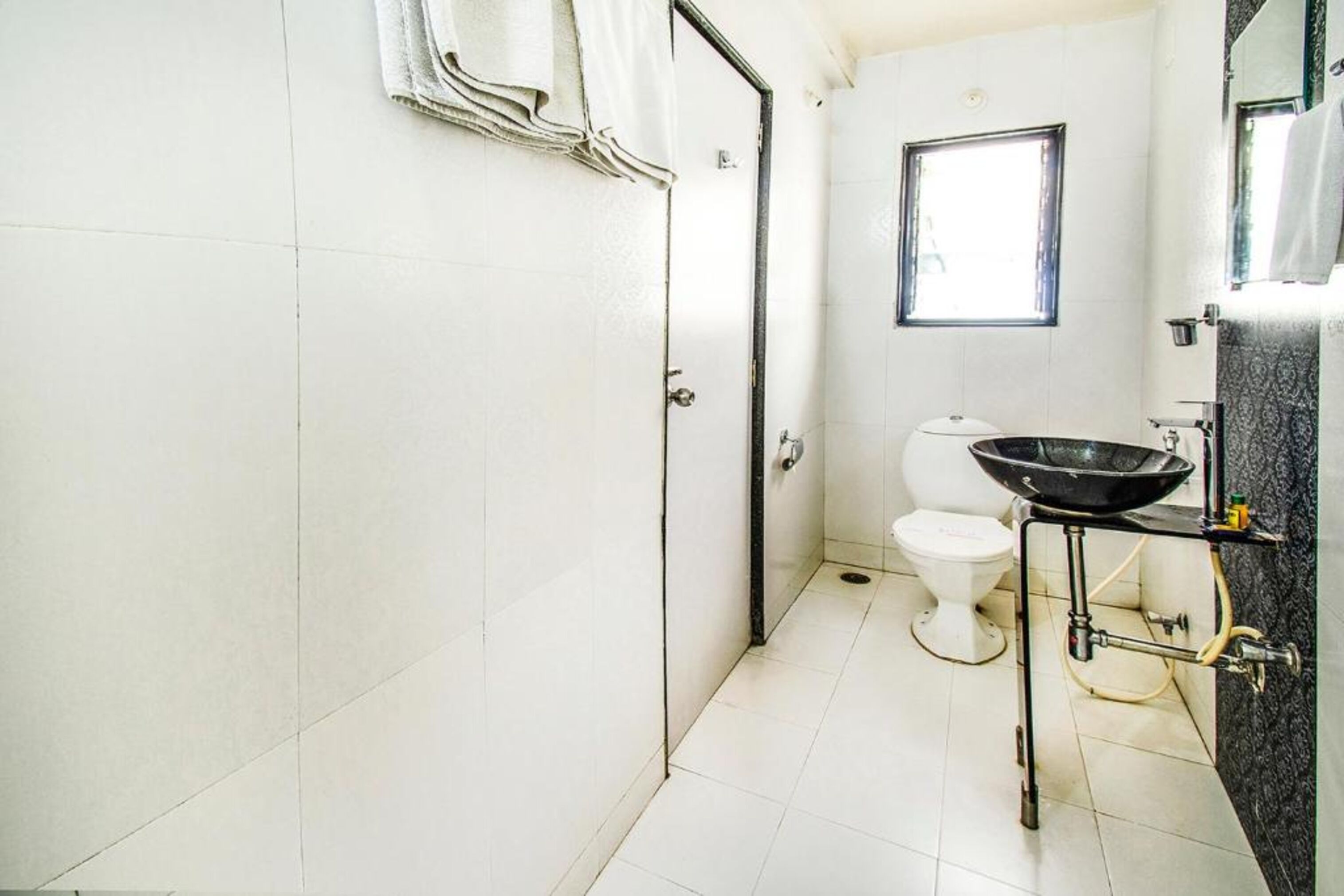 A bathroom with a toilet, a sink, and a window.