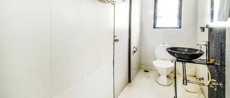 A bathroom with a toilet, a sink, and a window.