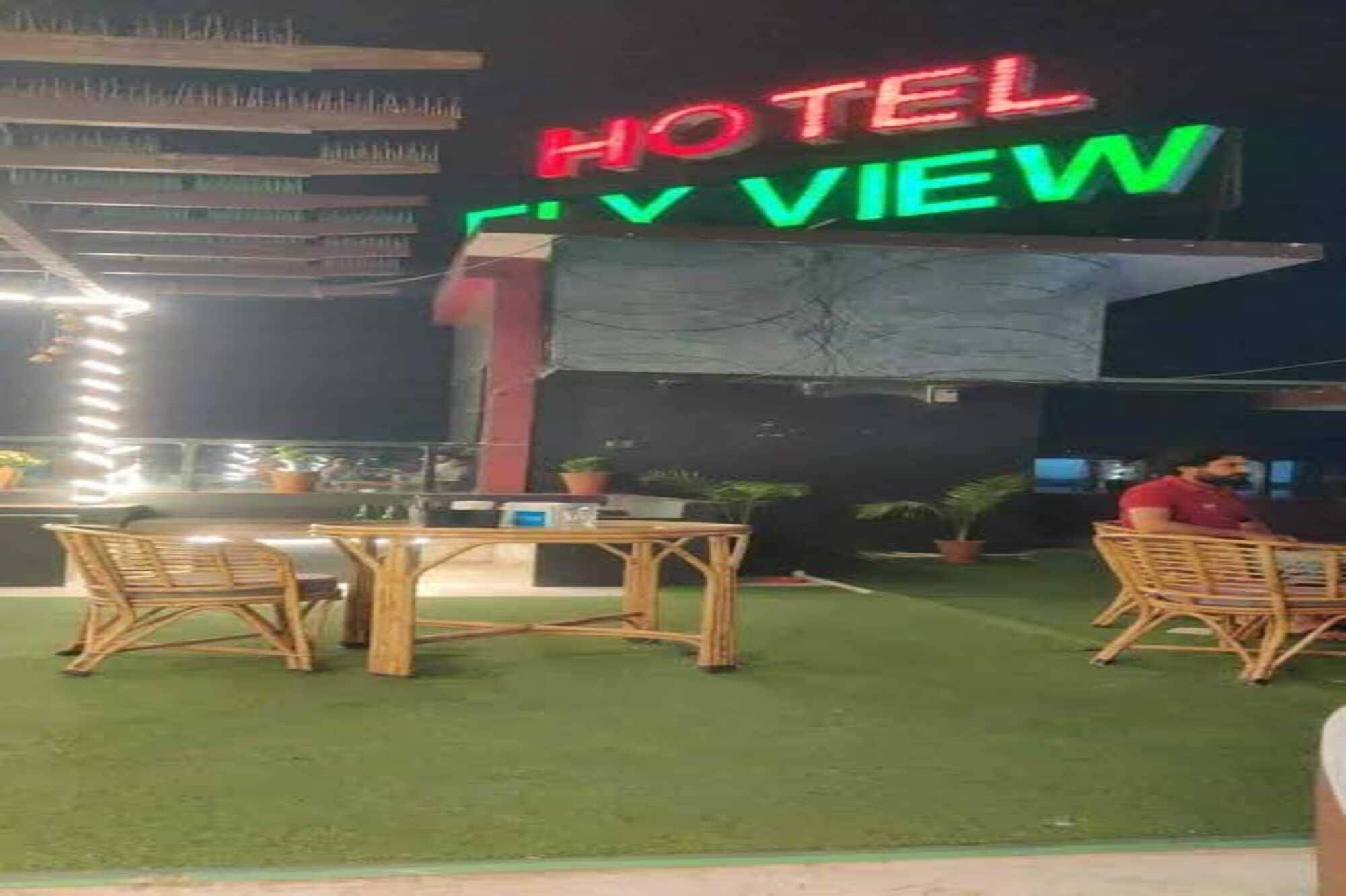 A hotel named 'HOTEL CITY VIEW' with outdoor seating and a view of the city.