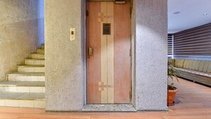 A door with a geometric pattern, a small window, and a doorbell. - Fabhotel Udhna Inn (Surat)