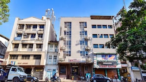 A hotel with multiple floors, balconies, and a signboard advertising various brands. - Fabhotel Rb Residency (Surat)