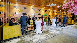 A modern hotel lobby with geometric wall patterns, seating areas, and a floral arrangement. - Fabhotel La Victoria (Surat)