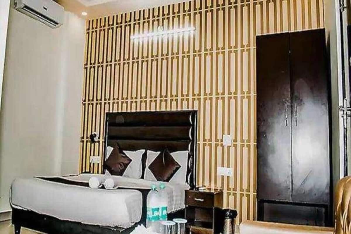 A bedroom with a bed, bedside tables, a wardrobe, and a wall-mounted panel design.