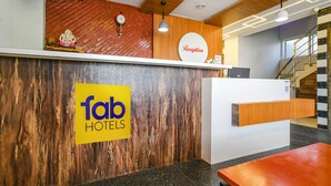 A reception area with a wooden reception desk, a clock, and a sign that reads "Reception". - Fabhotel Unity Landmark (Indore)