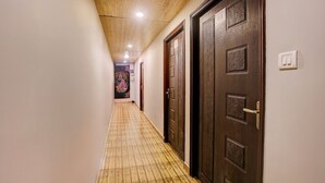 Un couloir doté d’un plancher en bois, de portes en bois foncé et d’un plafond équipé de luminaires encastrés.