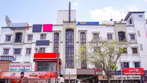 Un edificio a più piani con diversi esercizi commerciali, tra cui un hotel chiamato 'fab hotels'.