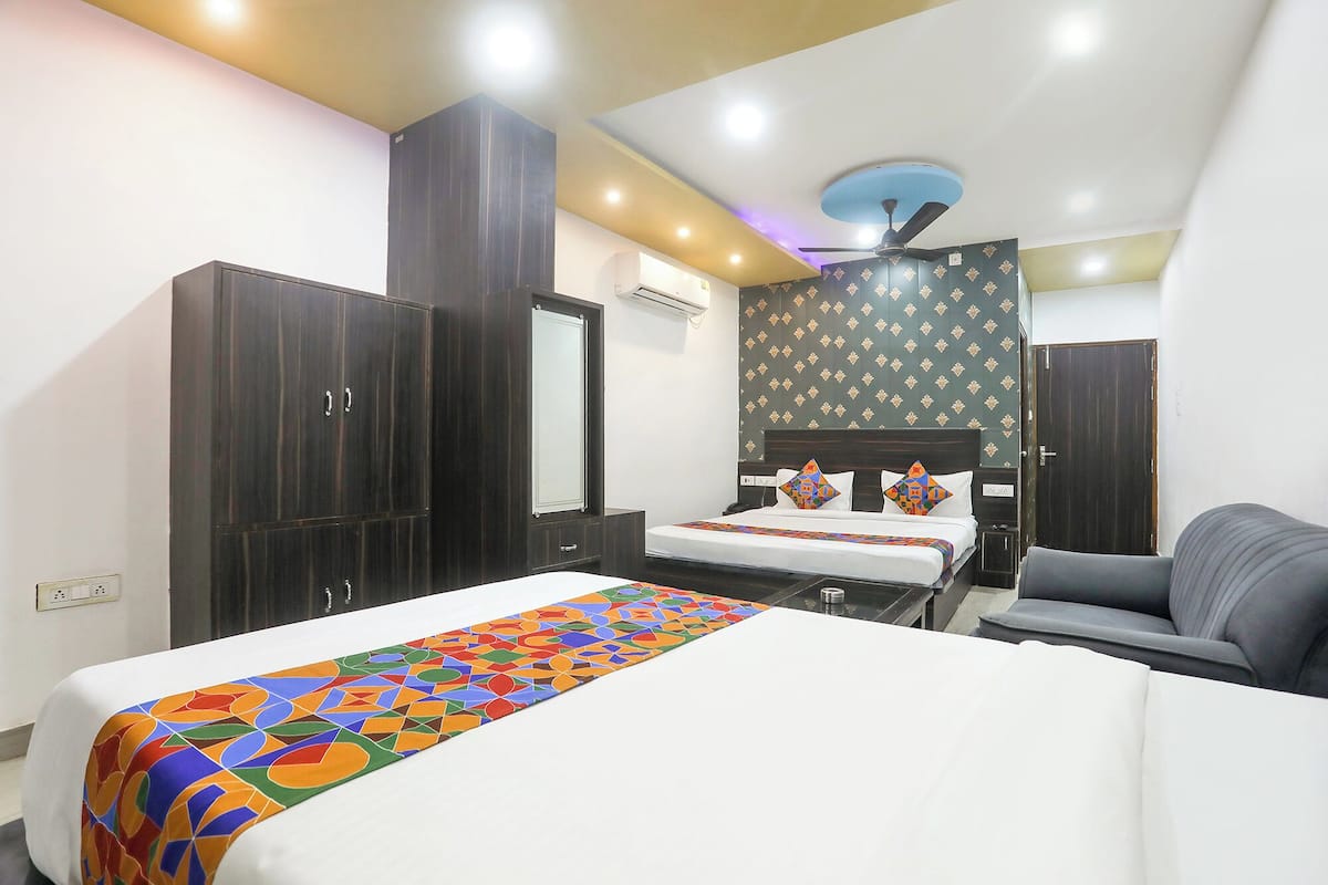 A hotel room with a bed, a desk, a chair, and a wardrobe.