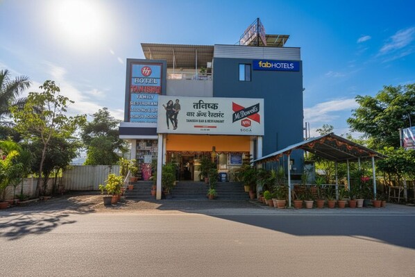 A hotel with a signboard advertising a family restaurant and a McDowell's soda outlet. - Via Tanishq (Sinnar)