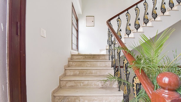 Un escalier avec des marches en marbre et des rampes richement décorées, aux couleurs noir et or.