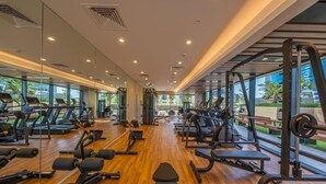 Un gimnasio moderno con máquinas de cardio, estaciones de pesas y bancos.