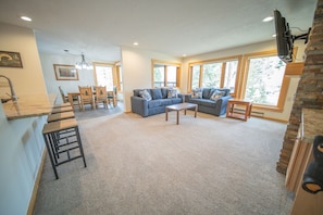 Relax in this stylish living area with a large sofa, coffee table, and dining space.