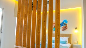 Un dormitorio con cama, mesita de noche y un separador de madera.