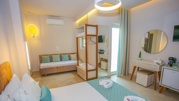 Habitación de hotel con cama, escritorio, espejo y una silla colgante.