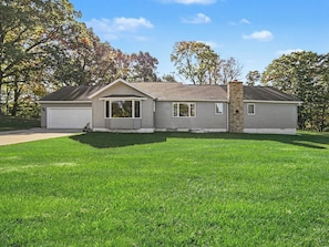 A two-story house with a garage, a small attached garage, and a well-maintained lawn.