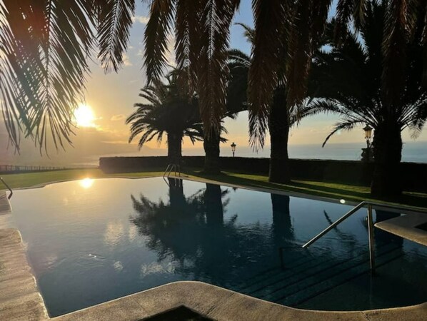 Relax by the pool surrounded by palm trees and enjoy a tranquil atmosphere.