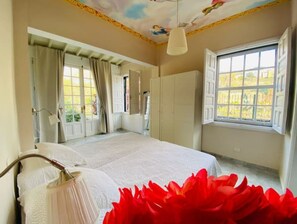Relax in this serene bedroom with a large bed and a door leading to an outdoor area.