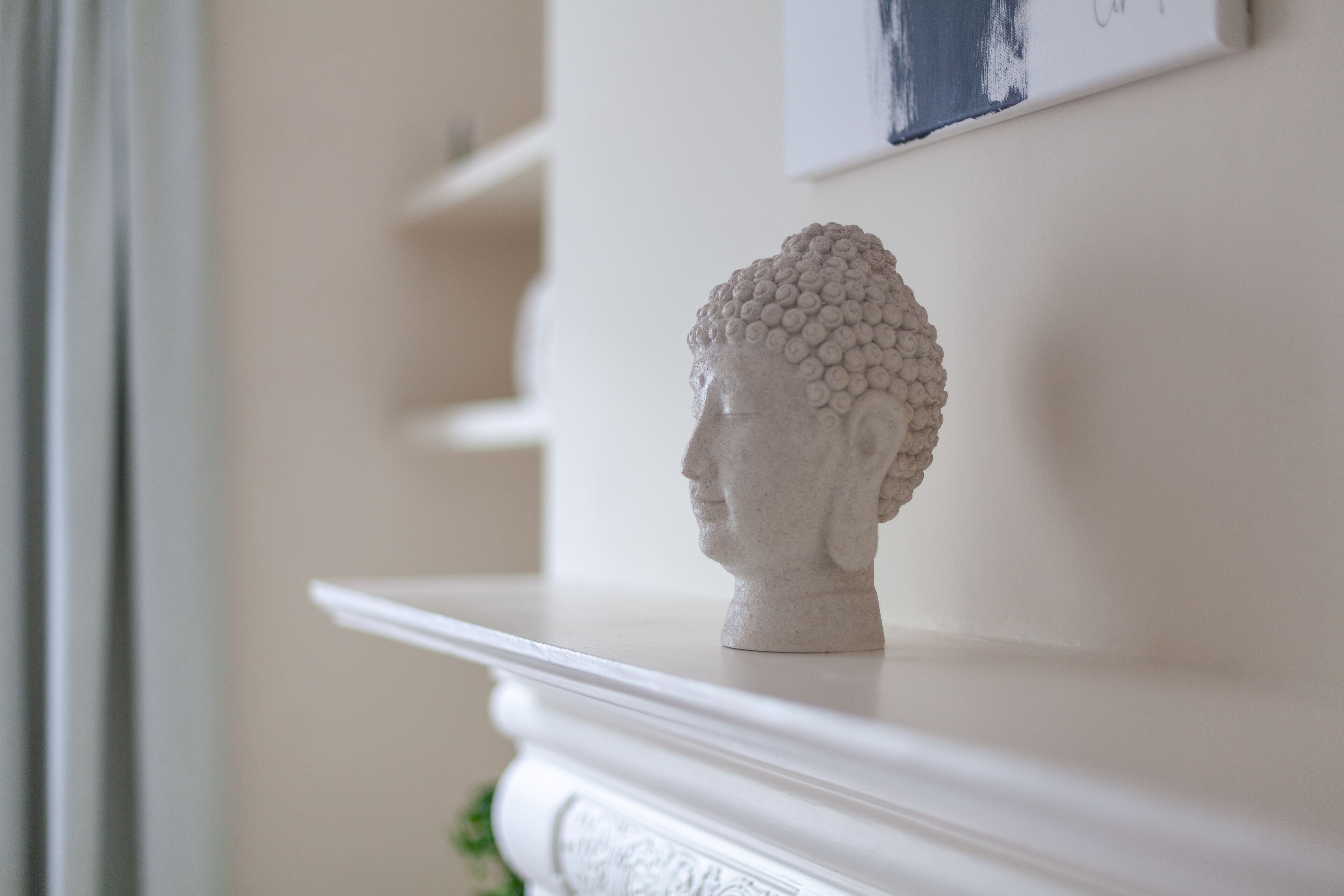 Een witte sculptuur op een schoorsteenmantel.