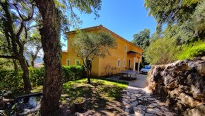 A yellow building with a stone pathway leading to a table tennis table. - Bastide Provençale au Cœur du Massif de L'esterel (FREJUS)