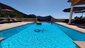 A clear swimming pool with lounge chairs and umbrellas, surrounded by a balustrade and a mountain backdrop. - Bastide Provençale au Cœur du Massif de L'esterel (FREJUS)