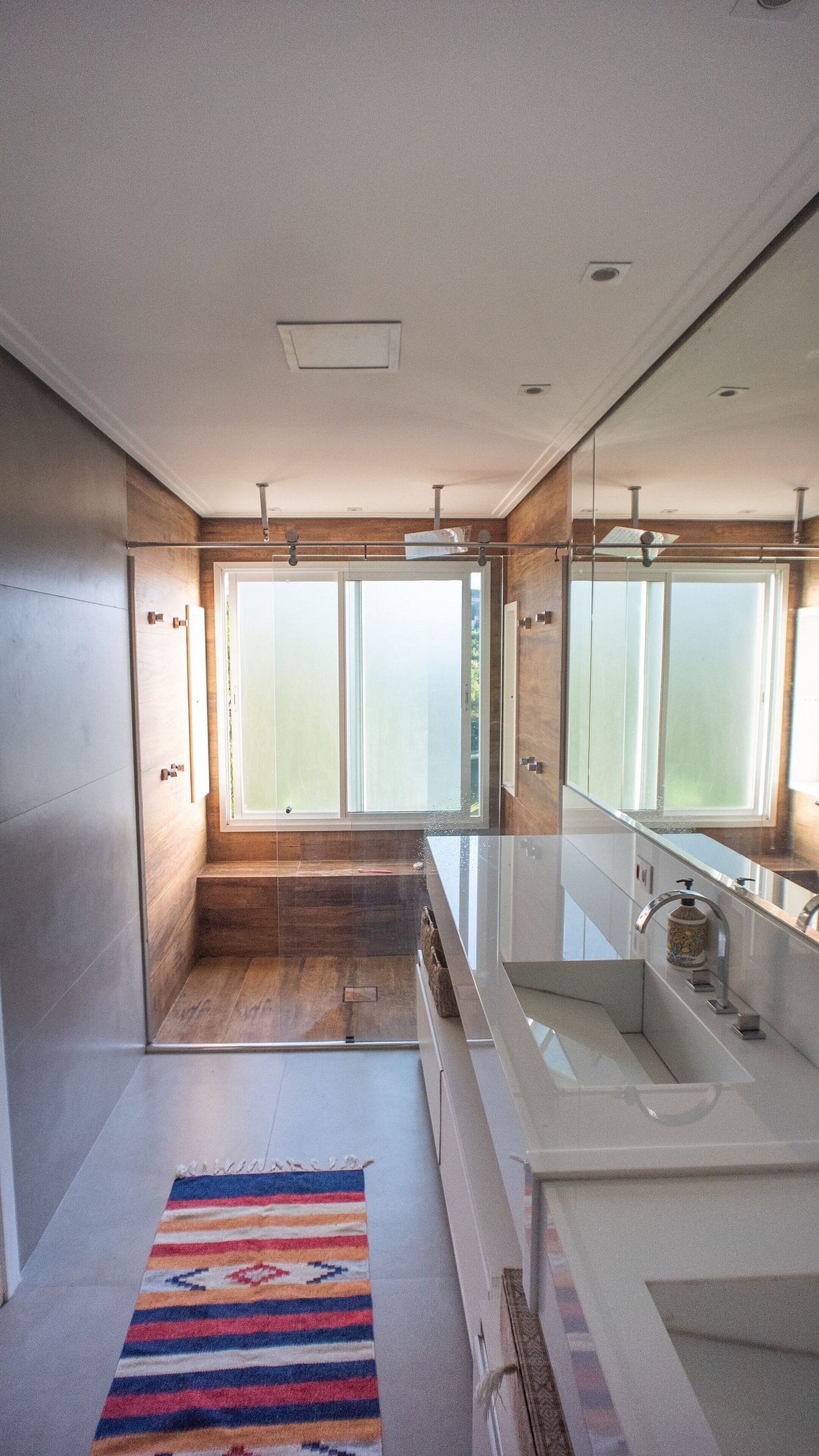 Une salle de bain moderne dotée d’une grande fenêtre, d’une baignoire et d’un espace douche.