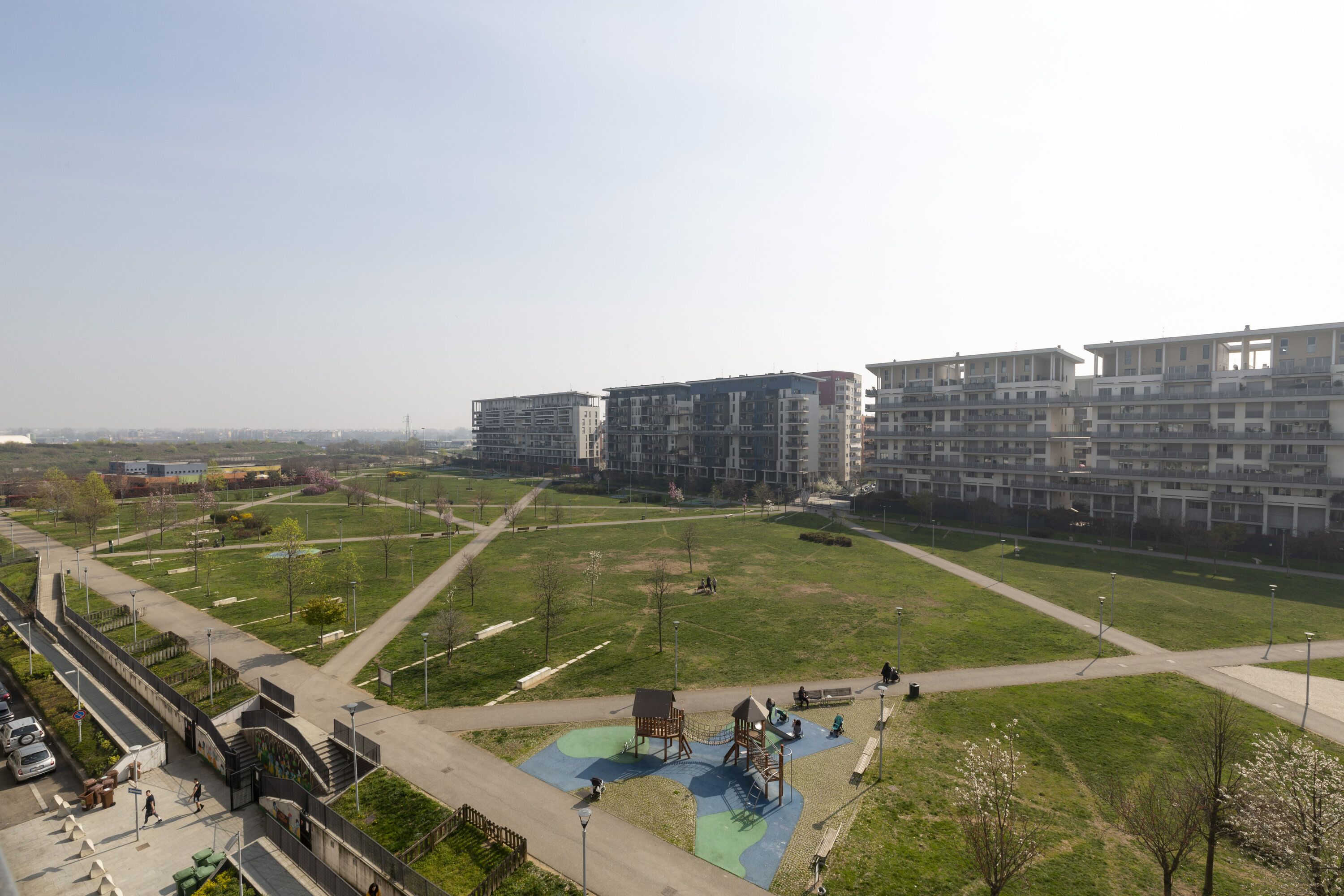A residential area with modern apartment buildings, a playground, and a park.