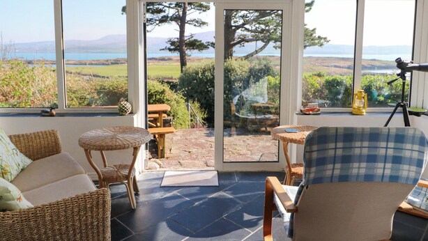 A room with a view of the sea, wicker furniture, and a telescope. - Whispering Pines (Glanlough)