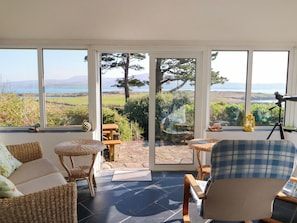 A room with a view of the sea, wicker furniture, and a telescope. - Whispering Pines (Glanlough)
