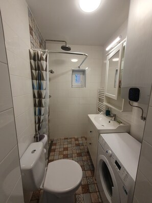 Regadera, secadora de cabello, toallas, papel de baño