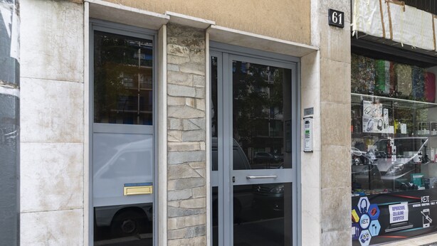 A building entrance with a stone facade, a glass door, and a sign with the number 61. - notaMi - Dimora Certosa (Milan)