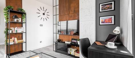 A modern office space with a desk, chair, bookshelf, and a wall clock.