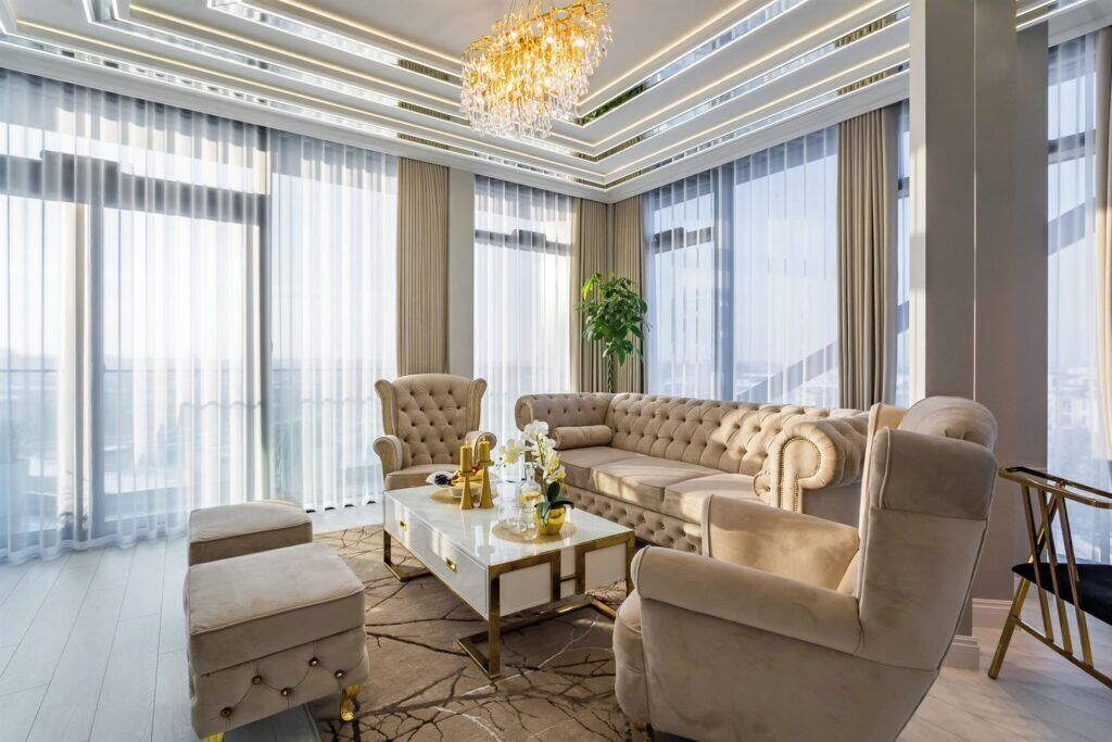 Un salón amplio con un sofá seccional beige grande, una mesa de centro y dos sillones.
