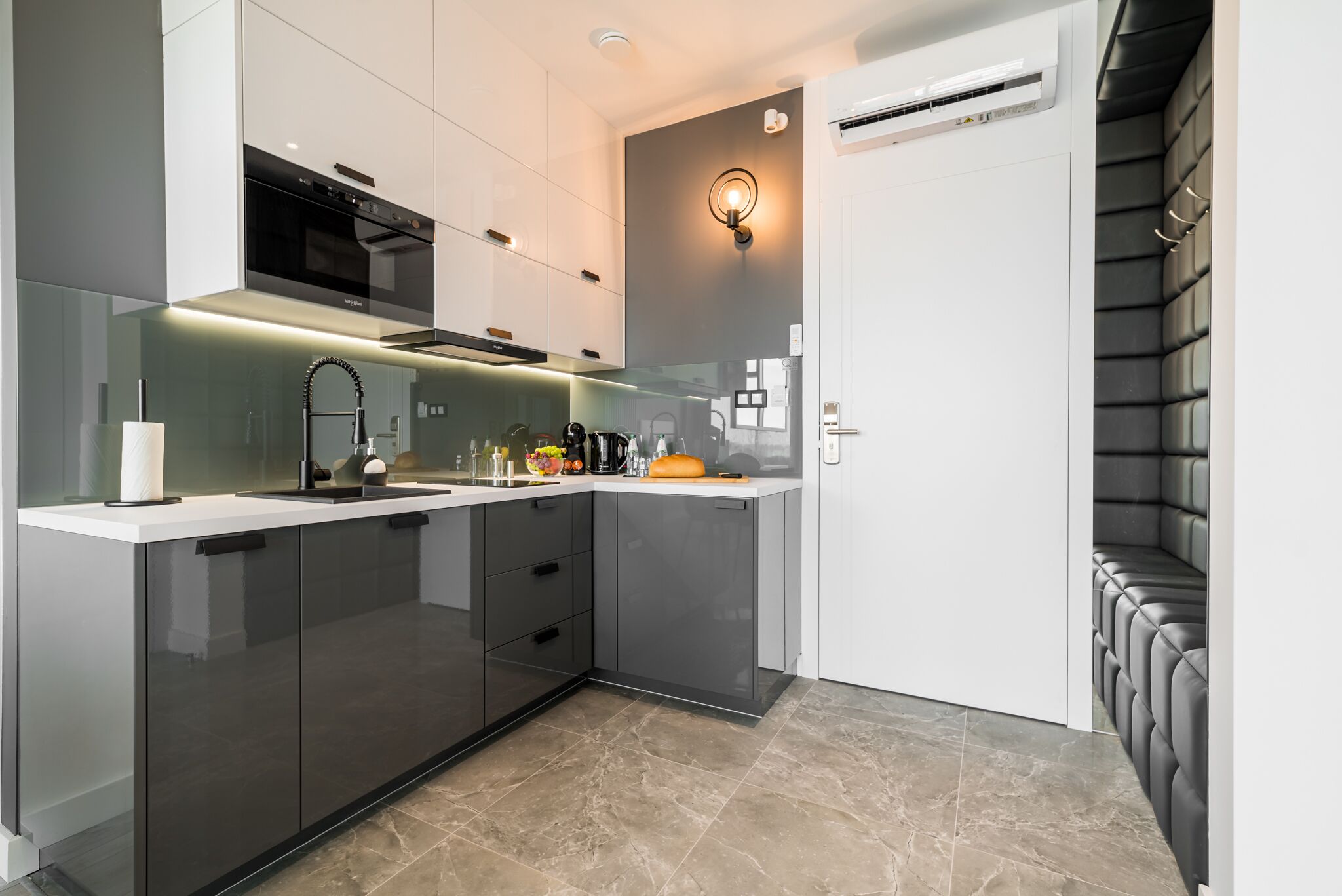 A modern kitchen with a built-in oven, a sink, and a countertop with a cutting board.