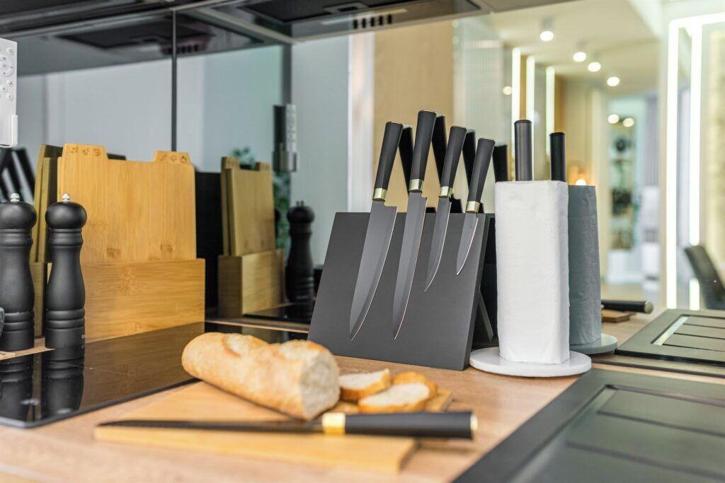 A kitchen counter with a loaf of bread, a cutting board, and a knife block with several knives.