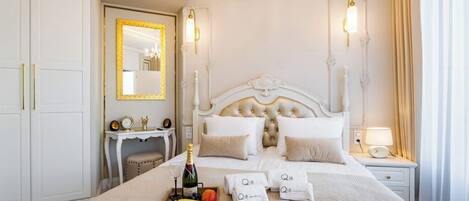 A hotel room with a large bed, a bedside table with a lamp, a mirror, and a wardrobe.