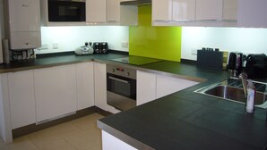 A modern kitchen with white cabinets, a microwave, a toaster, and a sink.