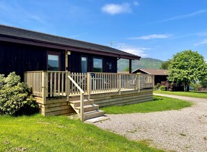 A wooden building with a balcony and a gravel path leading to it. - Blairlagan, stunning sea & mountains views (Hunters Quay)