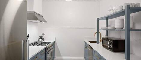 Cocina compacta con estufa a gas, microondas y piso con estampado blanco y negro.